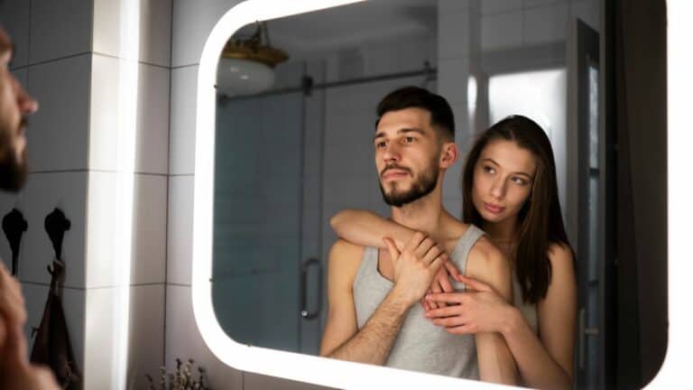 a picture of a couple standing in front of a mirror
