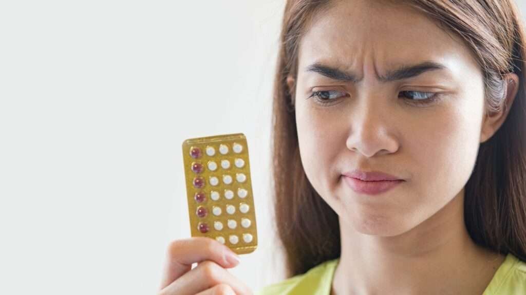 a woman looking at contraceptives pills